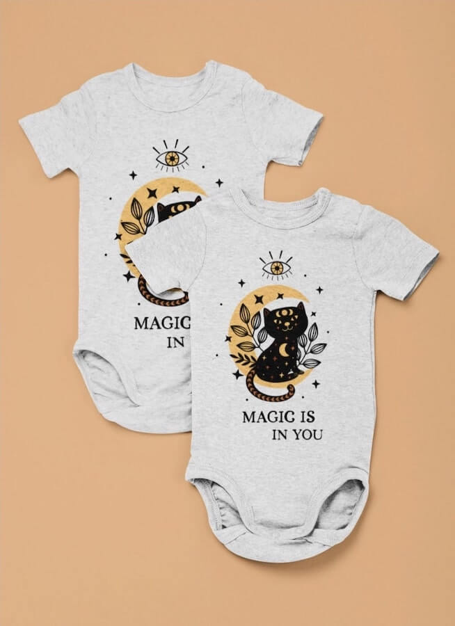 Bulk onesies with a design of a black cartoon cat and the text “Magic is in you.”