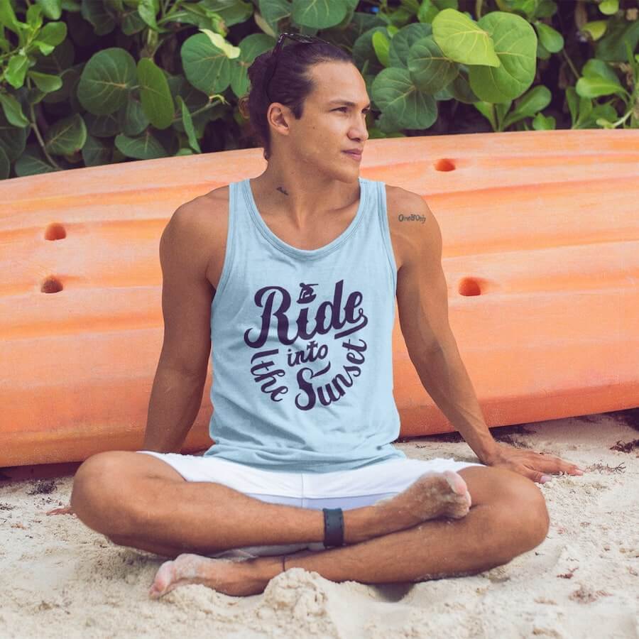 A man wearing a light blue tank with the text “Ride into the sunset.”