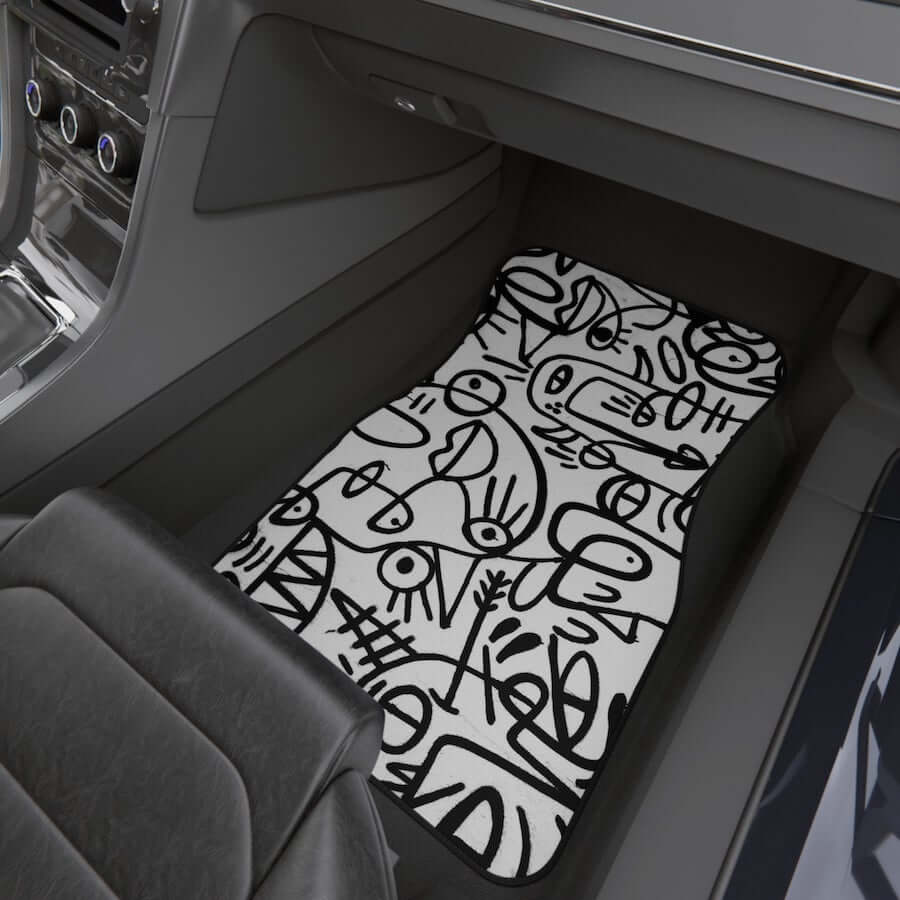 A white car mat with a doodle art design.