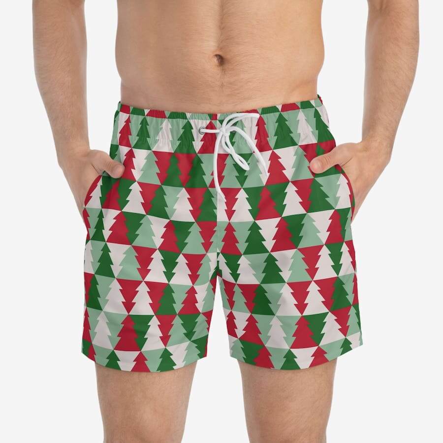 Swim trunks in stylized Christmas tree patterns in green, white, and red.