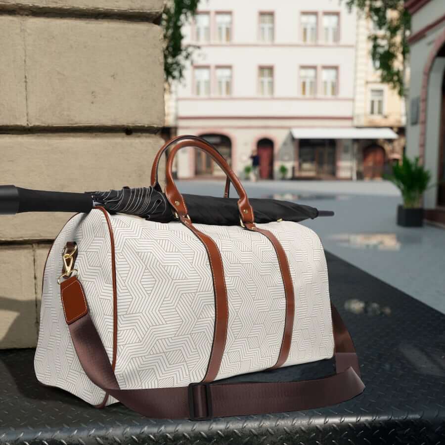 A white travel bag with brown handles.