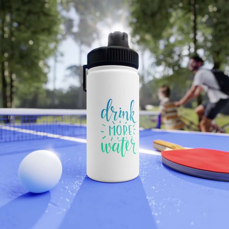 A water bottle on a table tennis table with the text: “Drink More Water.”