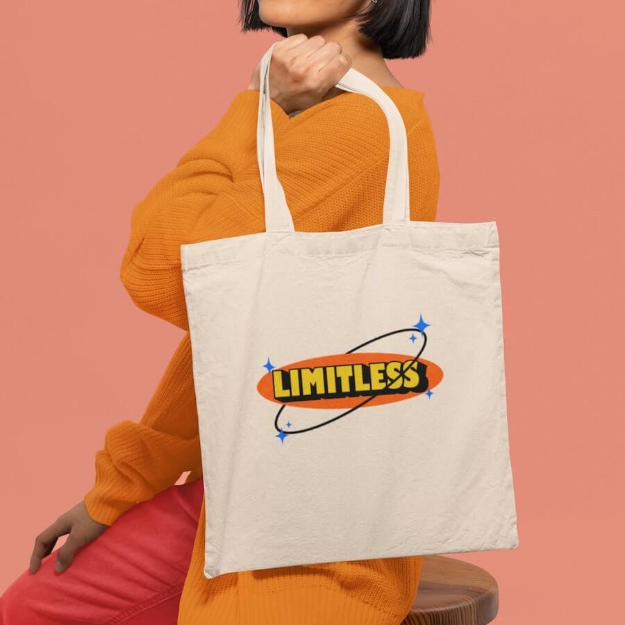 A person holding a tote bag with the word “Limitless” printed on it.