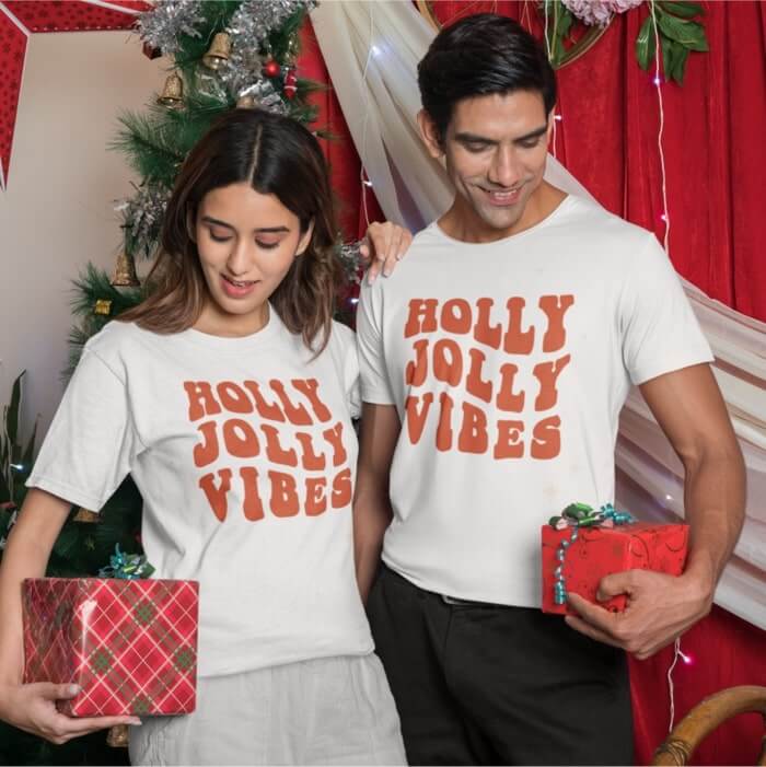 A couple wearing “Holly Jolly Vibes” Christmas t-shirts
