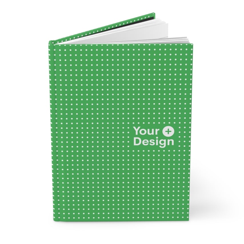 A slightly open green notebook with white dots and the “Your Design+” logo.