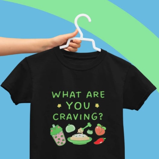 A black t-shirt with the text “What are you craving?” and images of various foods under it.