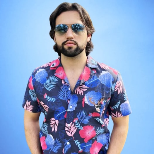 A man in sunglasses wearing a blue floral Hawaiian shirt.