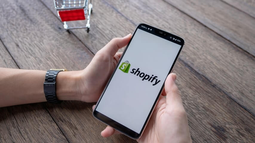 A person holding their phone with the Shopify app open.