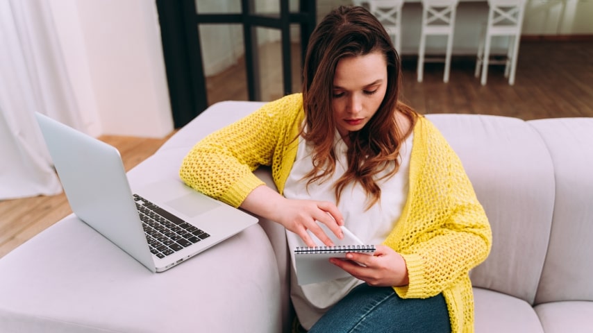 A woman using her laptop at home to work on her dropshipping business.