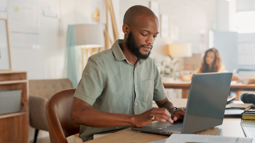 A man sitting at a desk with his laptop and learning about affiliate marketing.