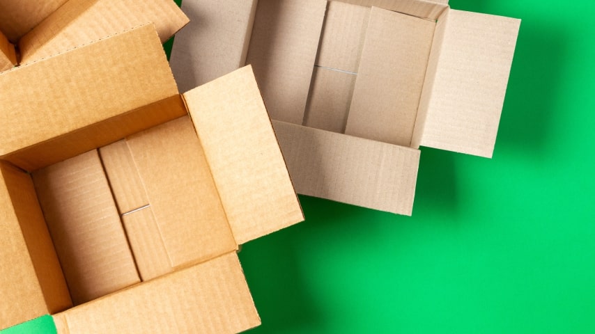 A pile of empty delivery boxes on a bright green background.