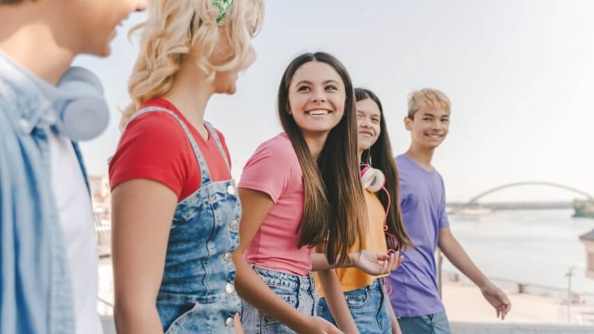 Five teenagers enjoying summer fun in colorful, denim-themed summer outfits.