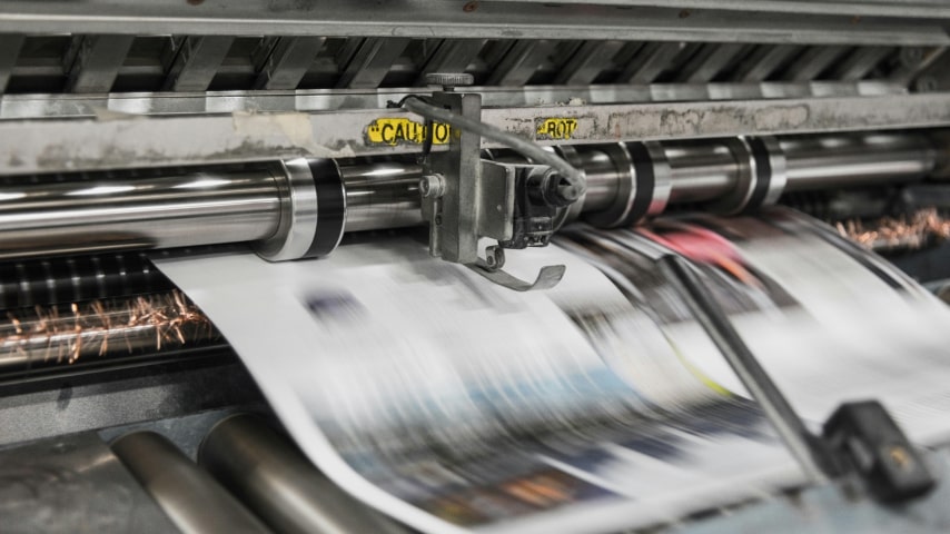 A press machine prints on paper.