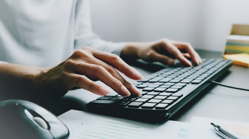 A man typing on a black keyboard.