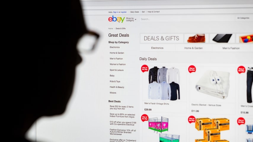 A man looking at a screen with the eBay homepage on it.