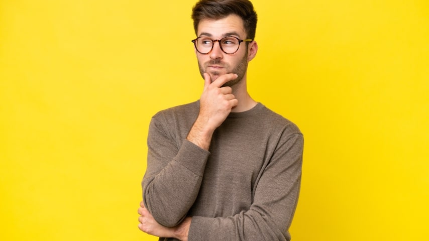 A man thinking with a yellow background behind him.