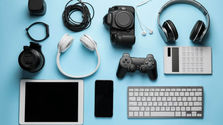 A set of electronics – phone, tablet, keyboard, camera, headphones, and others.