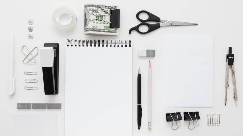 A set of office supplies – paper, scissors, stapler, and more.