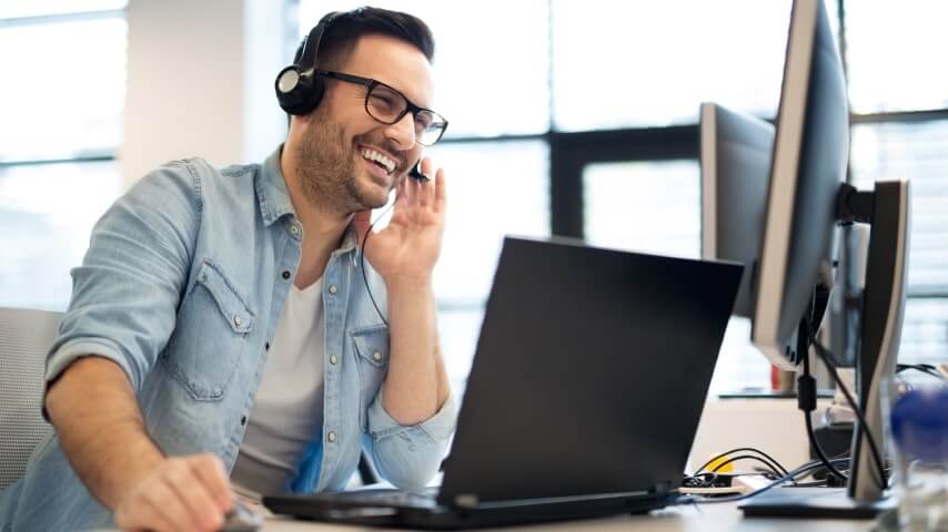 A smiling man talking to his Amazon customer on the phone.