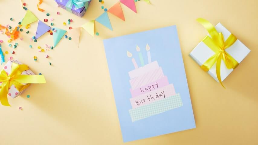 A greeting card with a design of a cake and the text saying, “Happy Birthday.”
