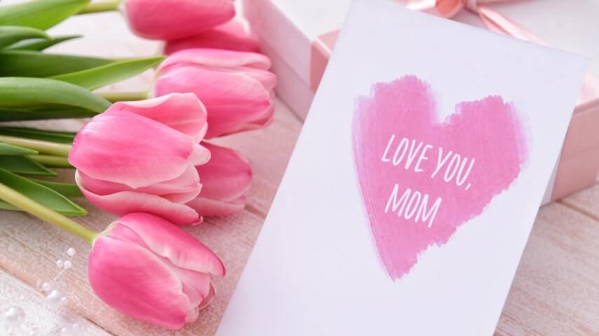 A greeting card with an image of a pink heart and the text “Love you, mom” in the middle.