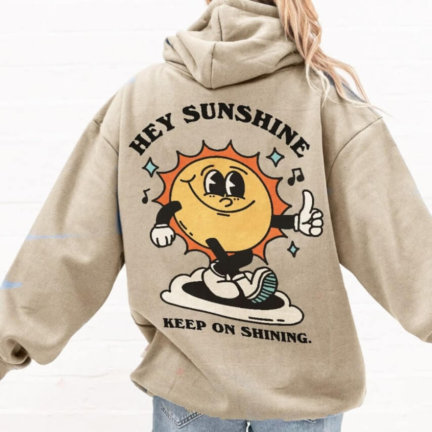 A hoodie design with the sun holding thumbs up and words "Hey sunshine, keep on shining."