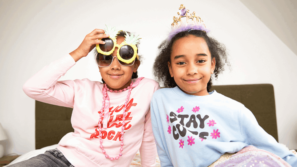 20 Back to school marketing phrases Two young smiling girls wearing different kids' party accessories.