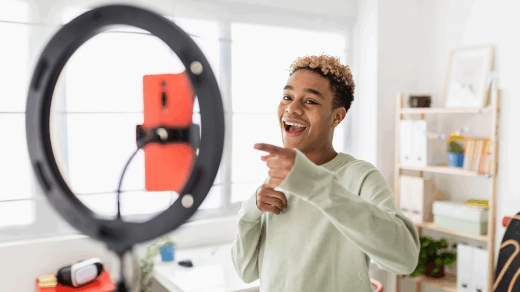 A young man is recording himself using a mobile phone.