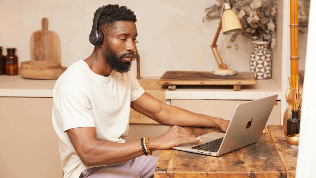 What do you need to start a successful business A man is sitting at a kitchen table and using a laptop.