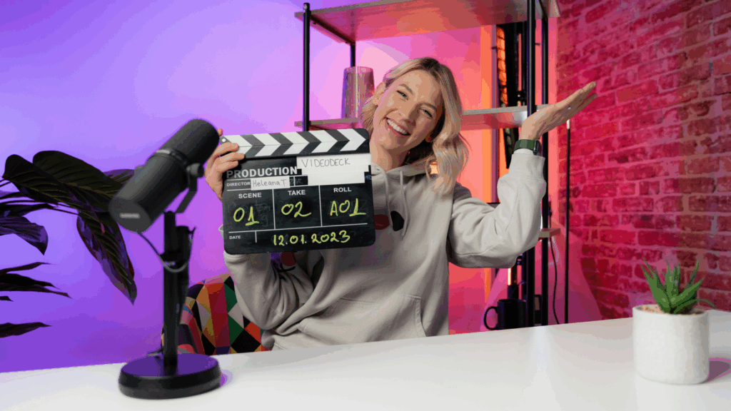 YouTube channel A smiling woman sitting in front of a microphone, holding a clapperboard.