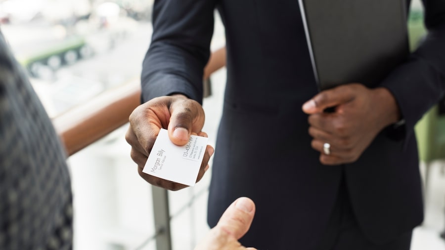 Business marketing templates A person giving a business card to another person.