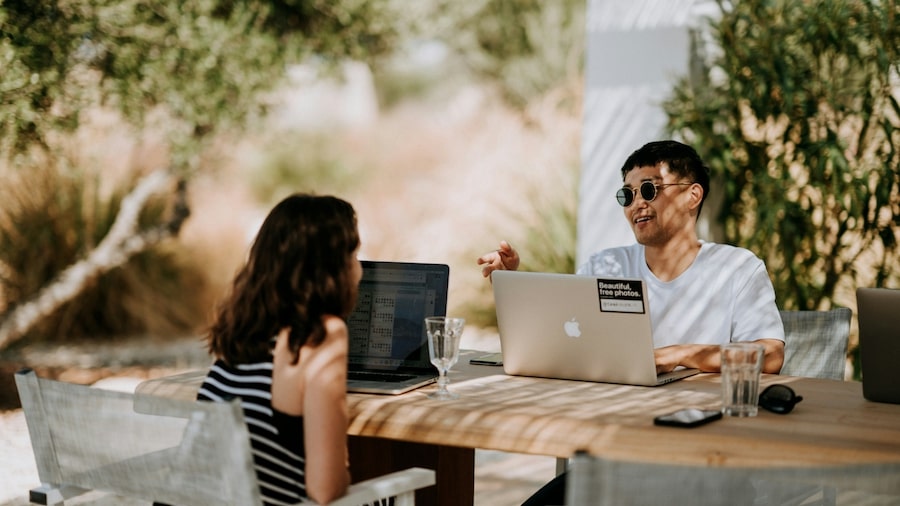 How much can you earn from Canva templates on Etsy Two people sitting with laptops and talking.