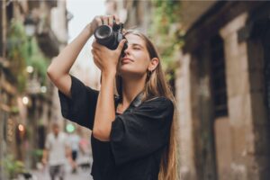 A woman taking photos in a city with a professional camera.