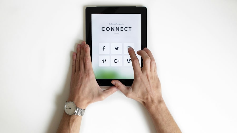How to promote your Canva templates outside of Etsy A person holding a tablet with social media icons on.