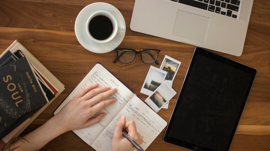 Why use Canva to create templates for Etsy Person writing in a notebook.