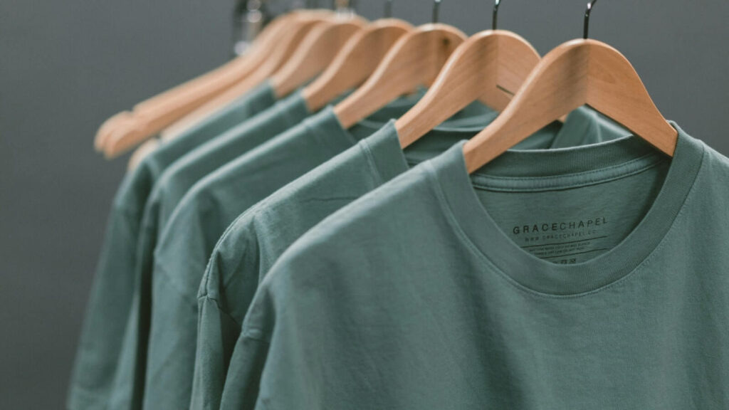 A bunch of t-shirts hanging on a clothing rack.