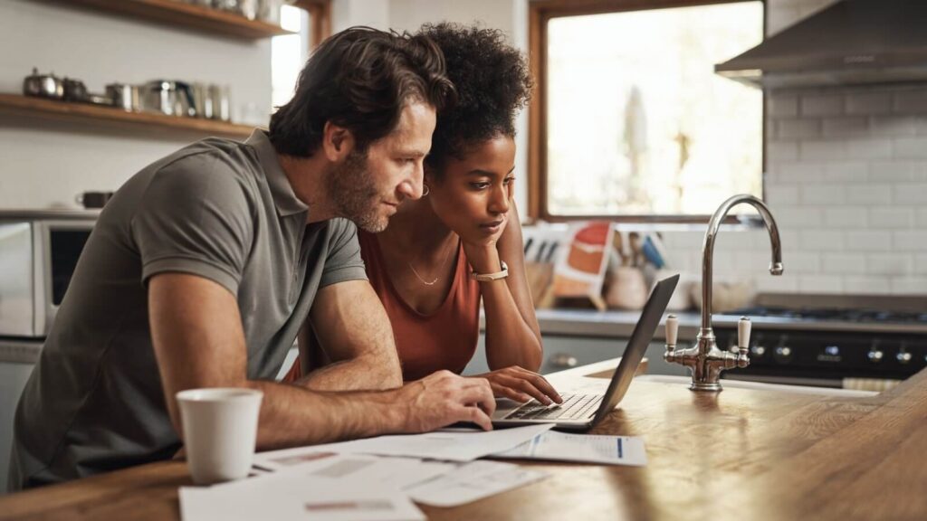 A man and a woman looking at a laptop screen.