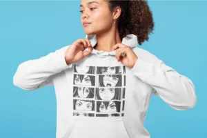 A woman in a white hoodie with a Manga comic print against a cyan background.