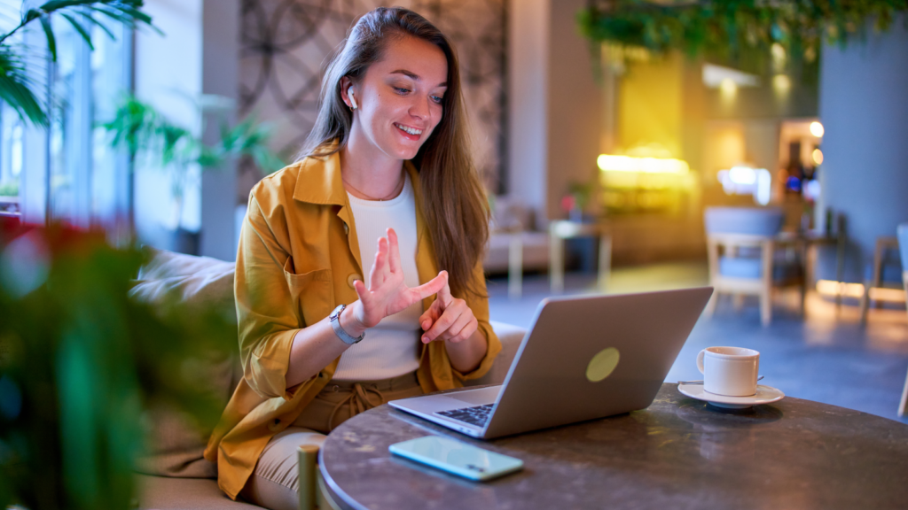 A woman talking to someone using a laptop.
