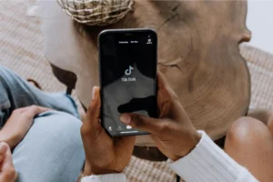 A person holding a mobile phone in their hand with the TikTok app open.