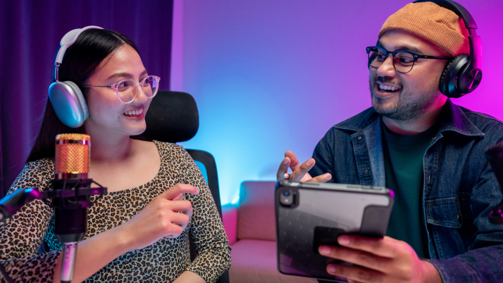A man and woman with headphones communicating with each other, discussing gaming topics.