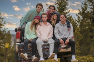 A group of young people sitting in the back of a pickup truck, wearing custom Gildan hoodies.