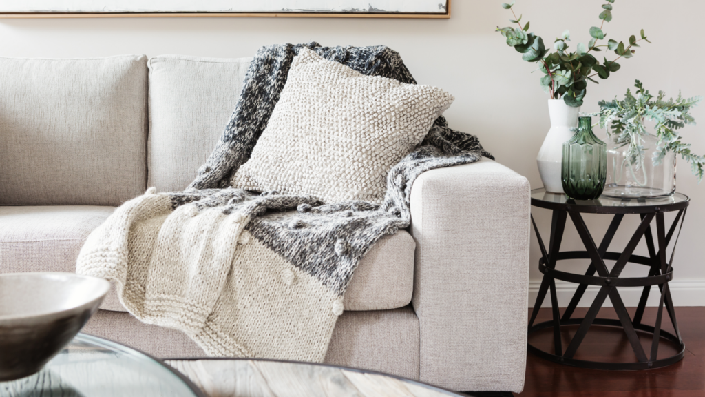 A cozy couch adorned with a soft blanket and decorative pillows, inviting relaxation and comfort.