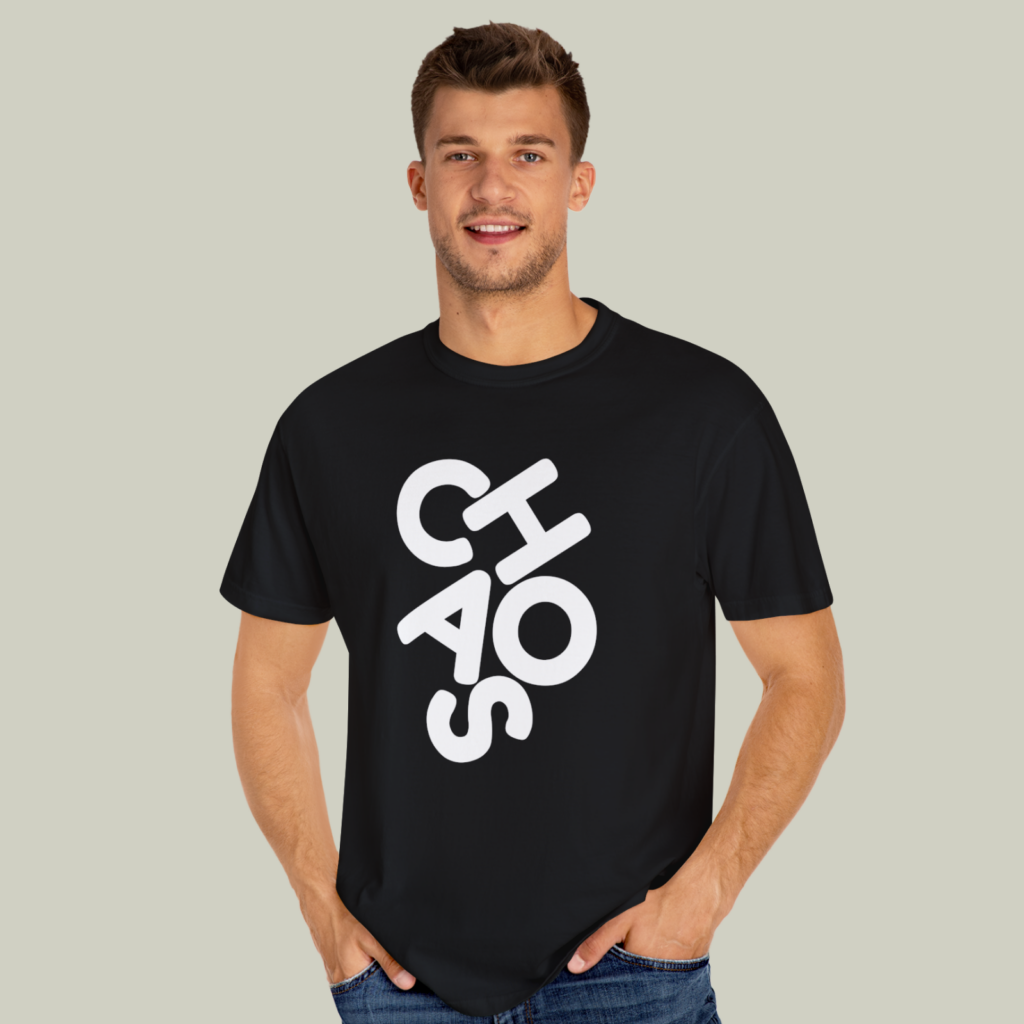 Black and white A man wearing a black and white “Chaos” t-shirt on a light olive green background.