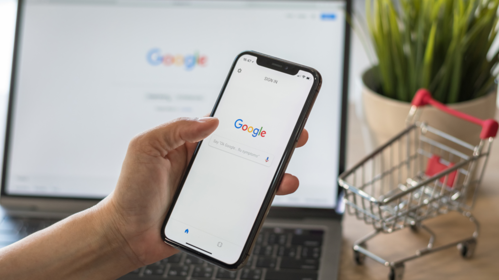 Etsy vs Shopify SEO A person holding a phone with Google Search on the screen.