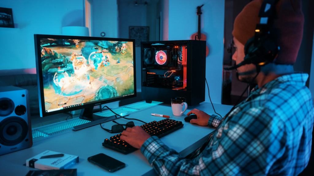 Gaming accessories Dropshipping business ideas A man dressed in a plaid shirt plays a video game on his computer screen.