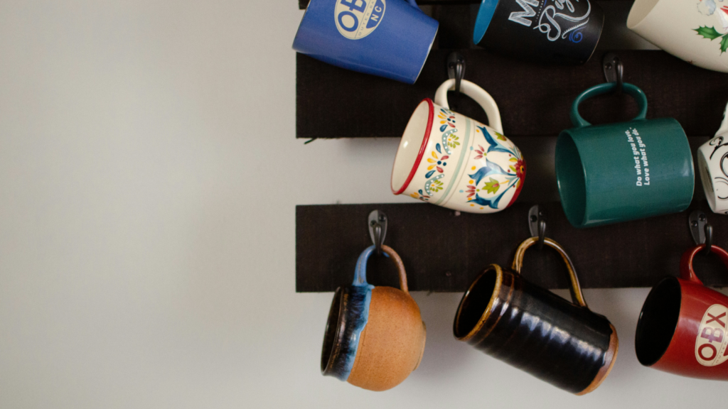 Mugs Dropshipping business ideas A collection of coffee cups displayed on a wall, showcasing different designs and sizes.