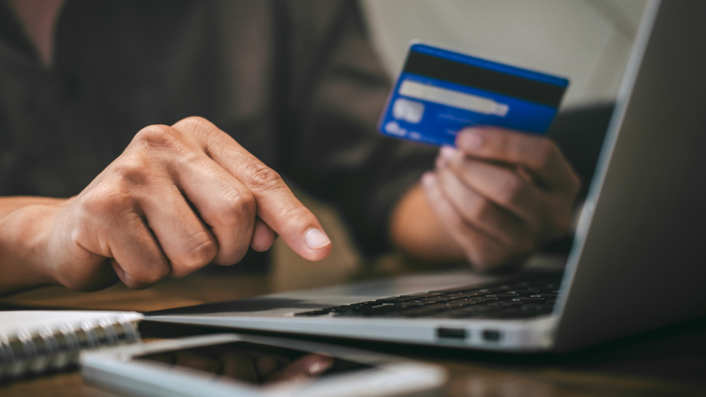 Price your custom stationery products and optimize your listings A person holding a credit card, making an online payment.