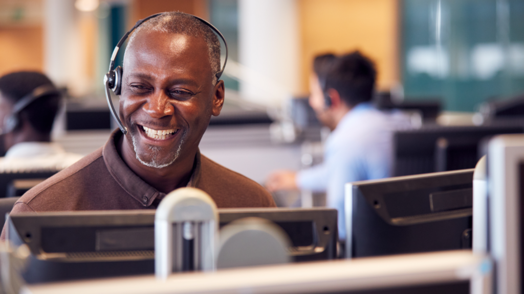 Shopify vs Etsy Customer support A smiling customer support specialist working from an office.