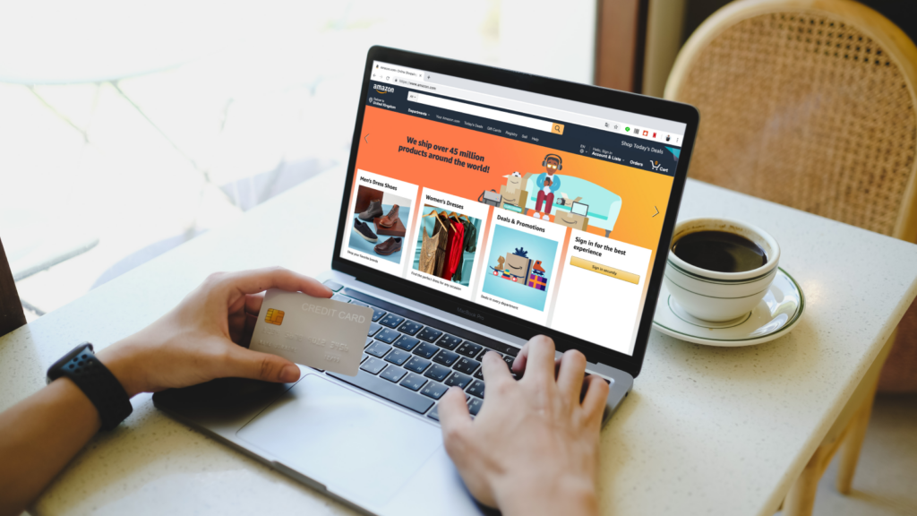 Shopify vs Etsy Fees and pricing A person sitting in front of a laptop, with Amazon’s homepage on the screen, holding a credit card in their hand.